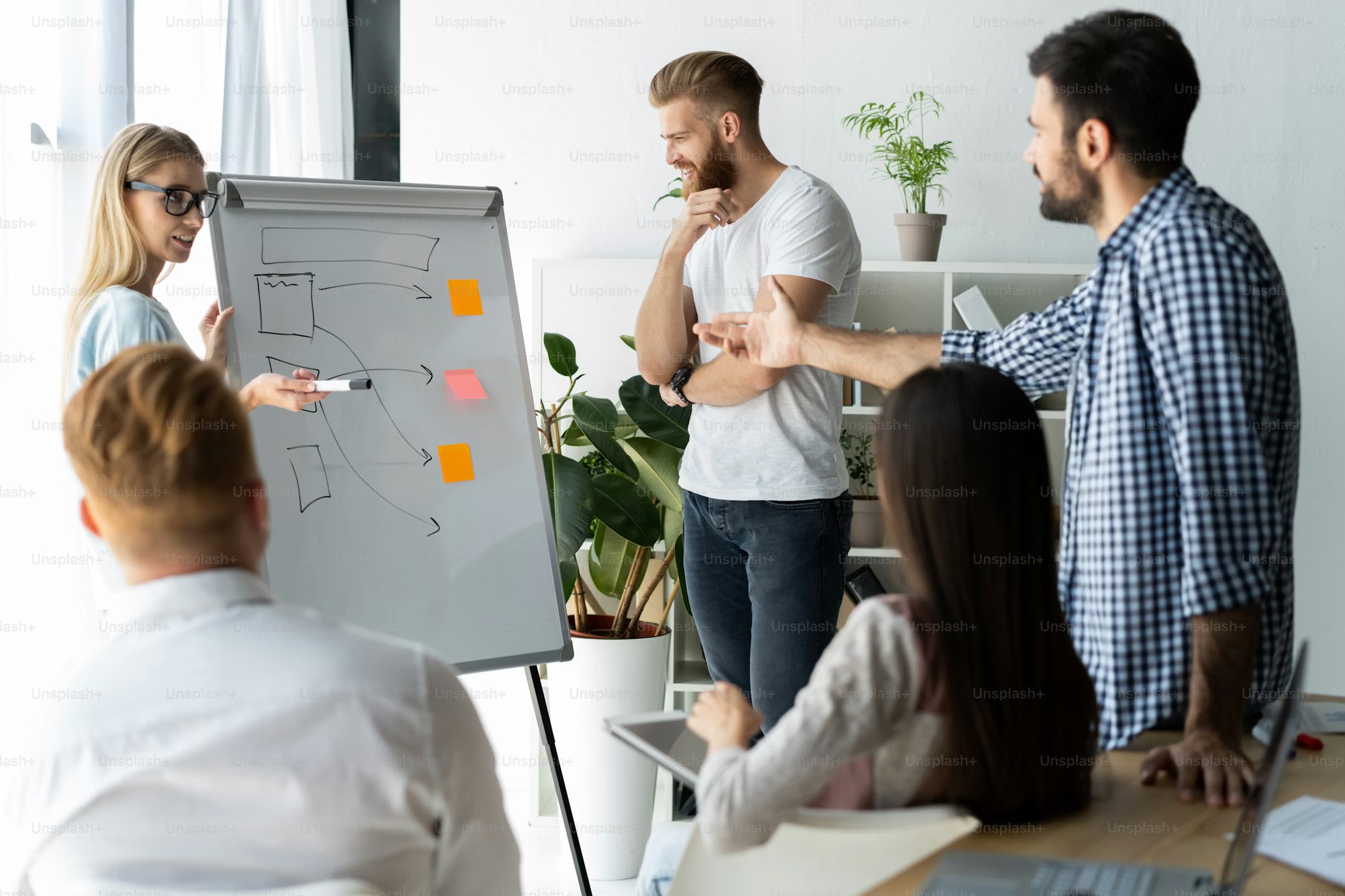 People working together around whiteboard on process flow